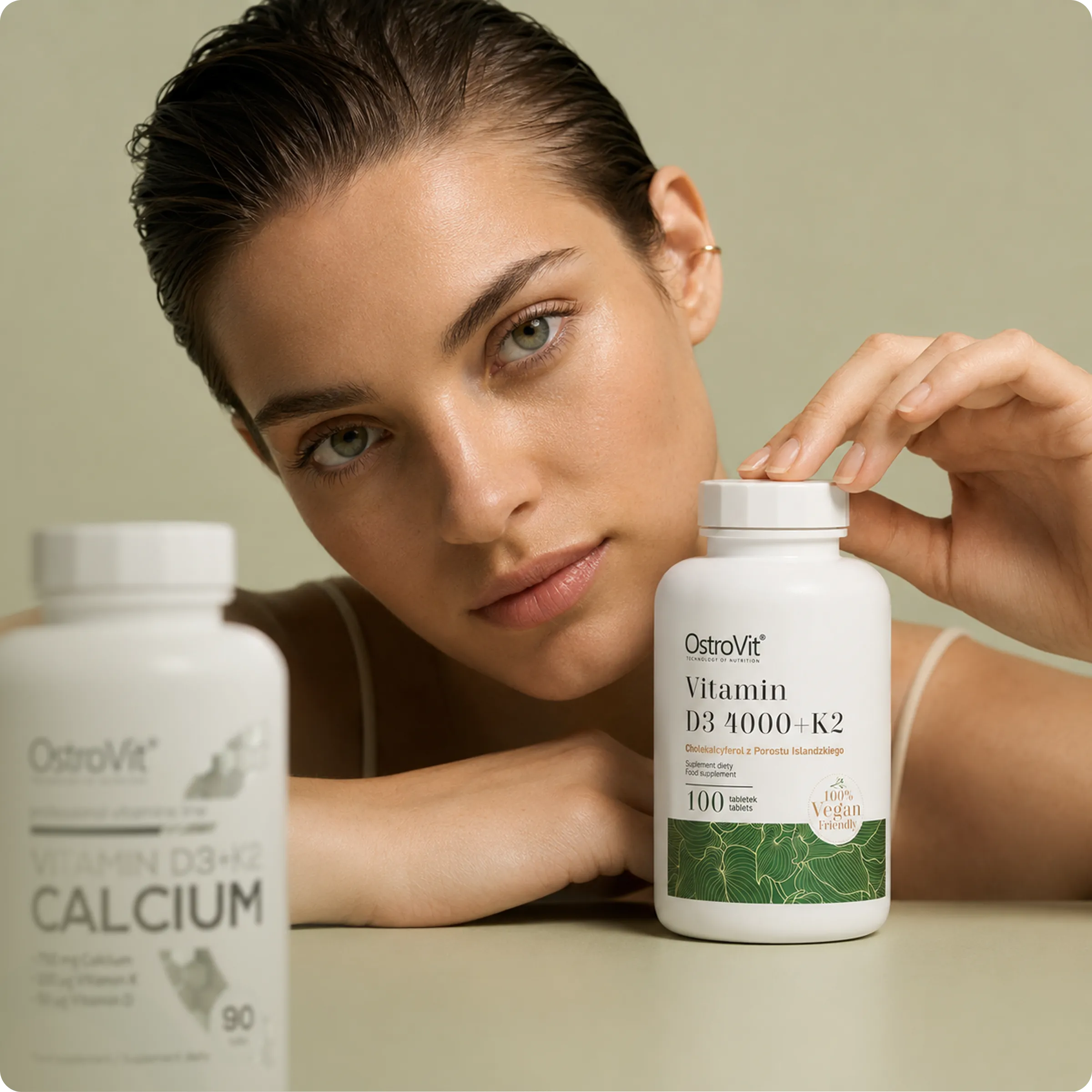 Woman holding a bottle of myGP vitamin D3+K2 alongside a calcium supplement